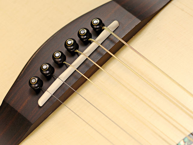 Faith Neptune Tremesi The ebony bridge pins are arranged in a curve to lessen stress along the grain.