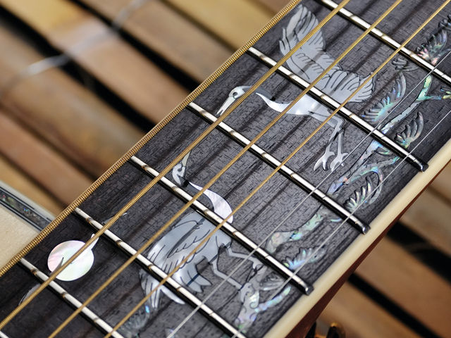 The neck features a distinctive crane overlay.