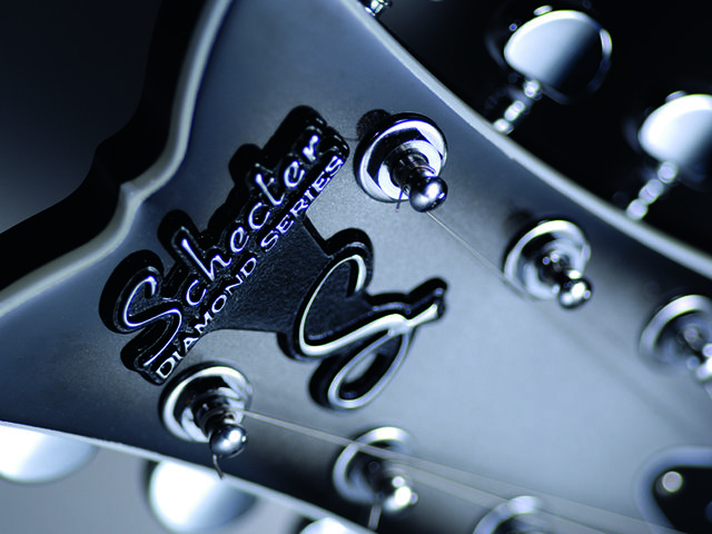 Fishtail headstock with raised metal logo.