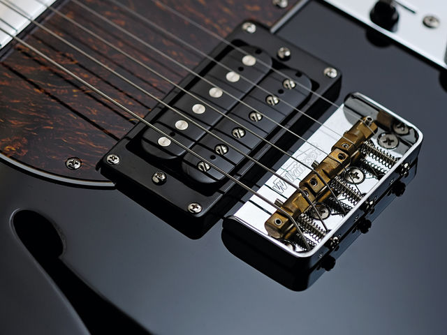 The Fret-King Country Squire Semitone's bridge has three compensated brass saddles.