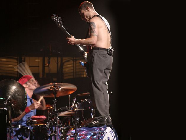 Flea standing on Chad Smith's bass drum, 2003