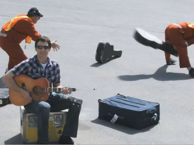Dave Carroll amidst some non-guitar-loving baggage handlers
