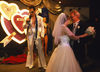 An Elvis impersonator serenades a newlywed couple at the Viva Las Vegas Wedding Chapel