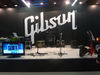 The (empty) Gibson artist stage Hey, it's Wednesday, alright? Everyone knows rock stars only hang out at trade shows on Saturdays... but wait a minute! Isn't that the guy from Annihilator's guitar?
