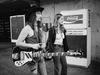 Deep Purple bassist Roger Glover strolls backstage with a young woman in 1973